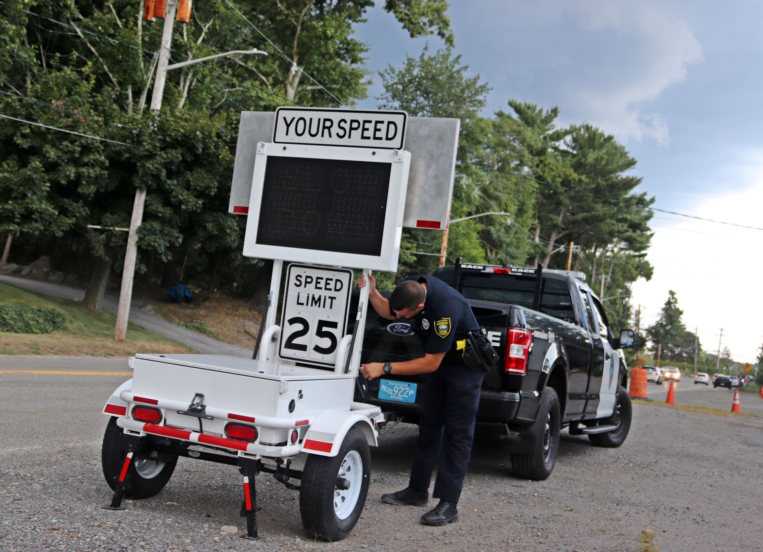 Officer setting up speed awareness trailer along the road